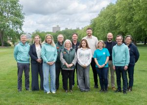 group of business owners that are sponsoring Long walk Live standing on a field with Windsor Castle in the background